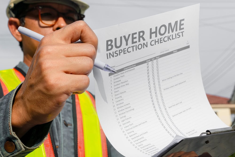 Inspector reviewing a buyer home checklist, ensuring every detail is covered.