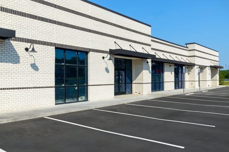 Freshly paved parking and brick-lined storefronts await new businesses.