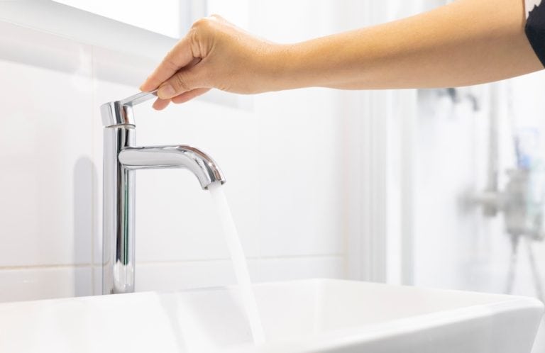 Turning on the tap for a refreshing splash of water.