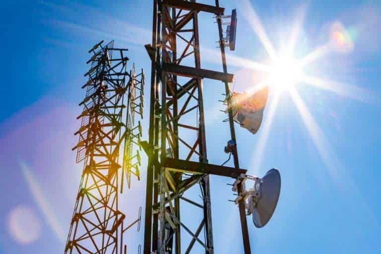 Telecommunication towers reach for the sky, transmitting signals under the blazing sun.