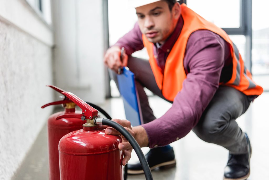 Safety inspector checks fire extinguishers during a routine building inspection.
