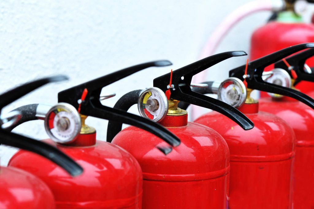 A row of red fire extinguishers ready for emergency use.