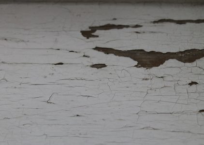 Timeworn white paint peels away, revealing the rich texture of aged wood beneath.